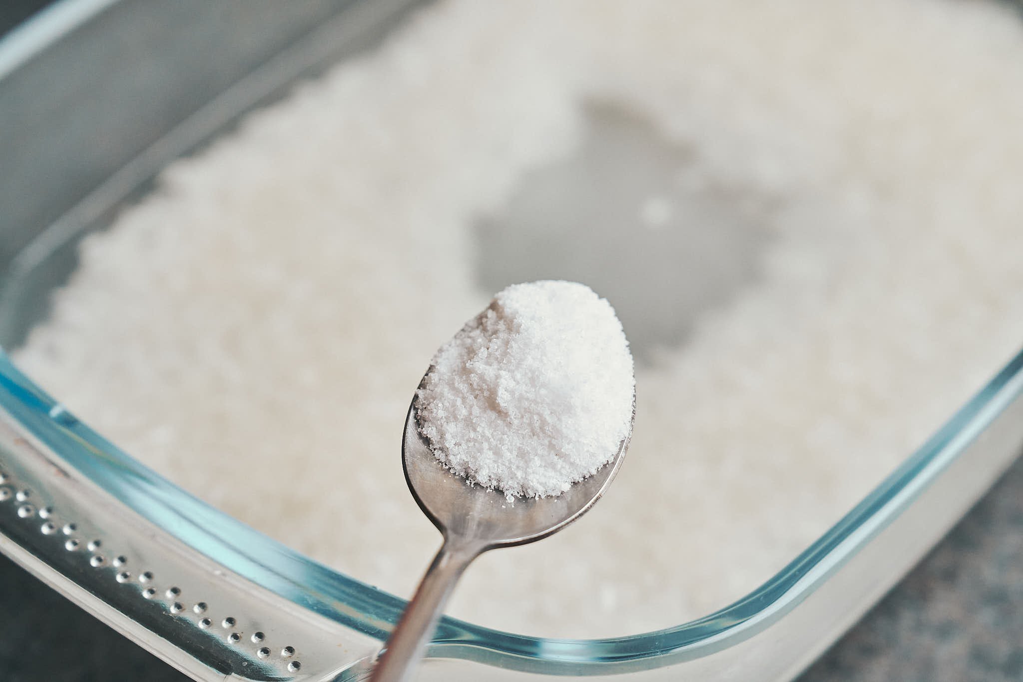 adding salt to rice in baking dish