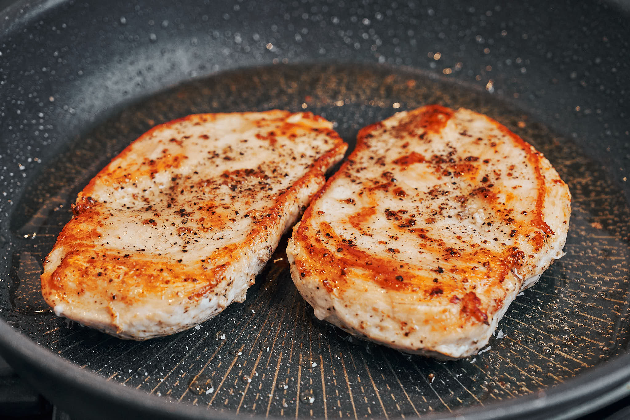 Chicken cutlets seared until golden in a skillet
