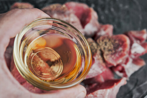 adding oil to seasoned pork tenderloin medallions