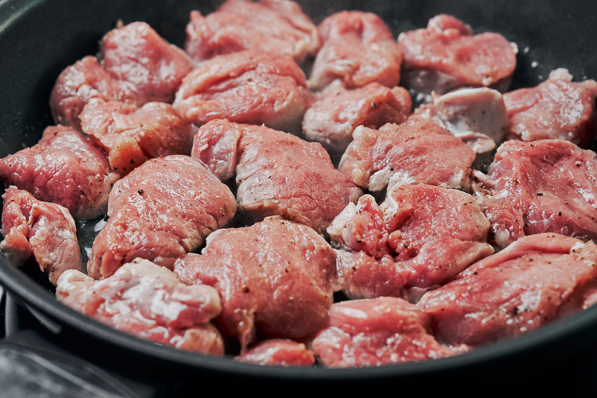 pork tenderloin medallions searing in a skillet