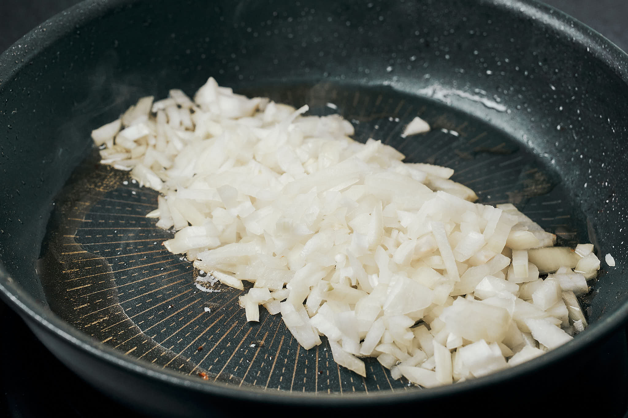 chopped onion cooking in a skillet
