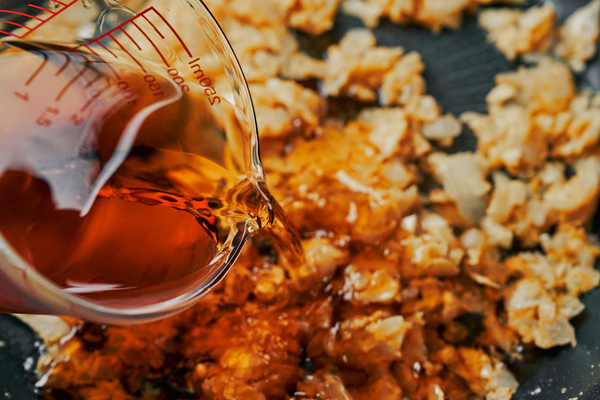 pouring cognac into the skillet to deglaze