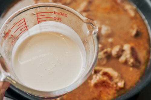 measuring heavy cream for creamy pork tenderloin sauce