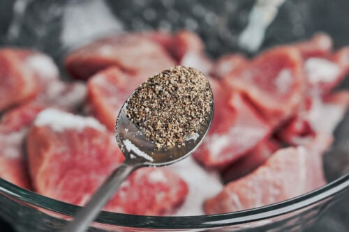 adding black pepper to pork tenderloin medallions