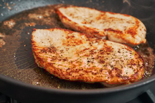 chicken developing a golden crust while cooking in the skillet