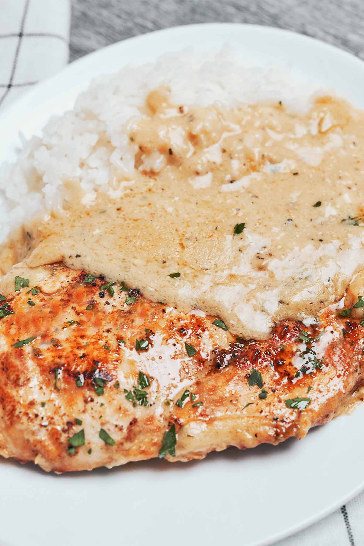 creamy parmesan chicken with golden edges and extra sauce for spooning