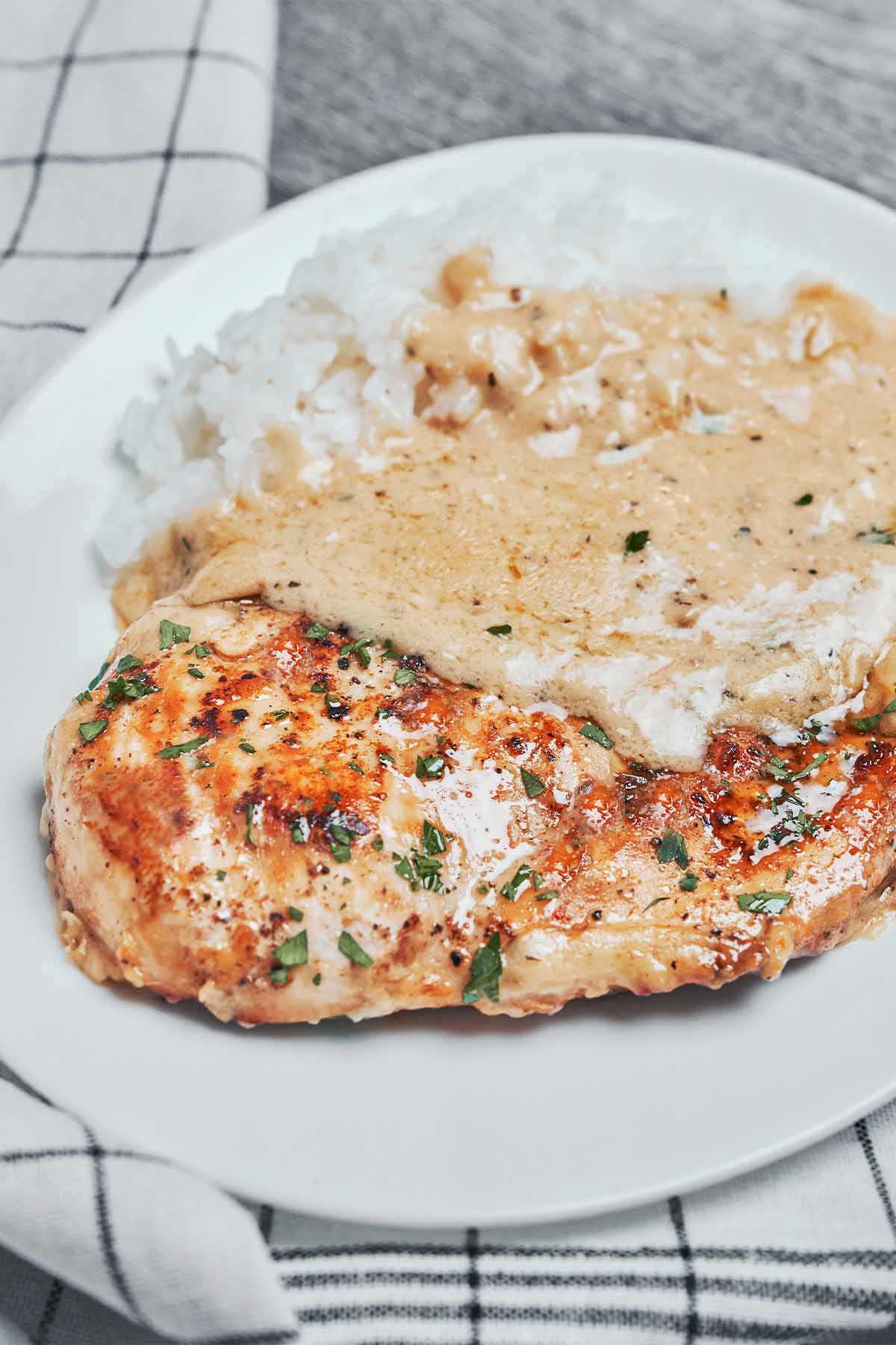 creamy parmesan chicken served over rice with creamy garlic parmesan sauce
