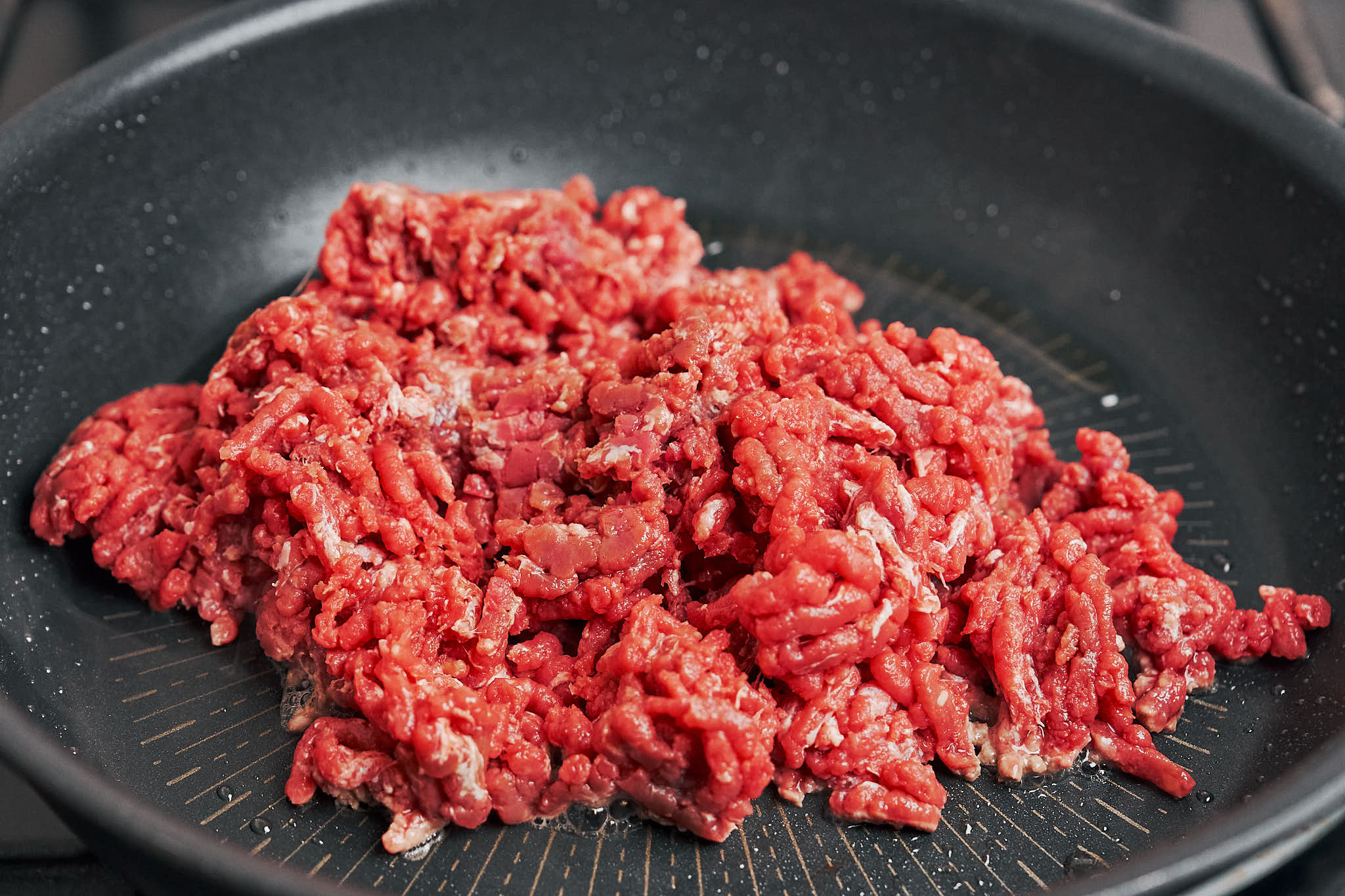 ground beef just added to the skillet to start browning