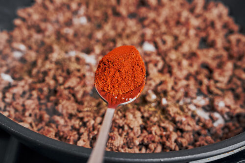 sprinkling smoked paprika over browned ground beef for extra flavor