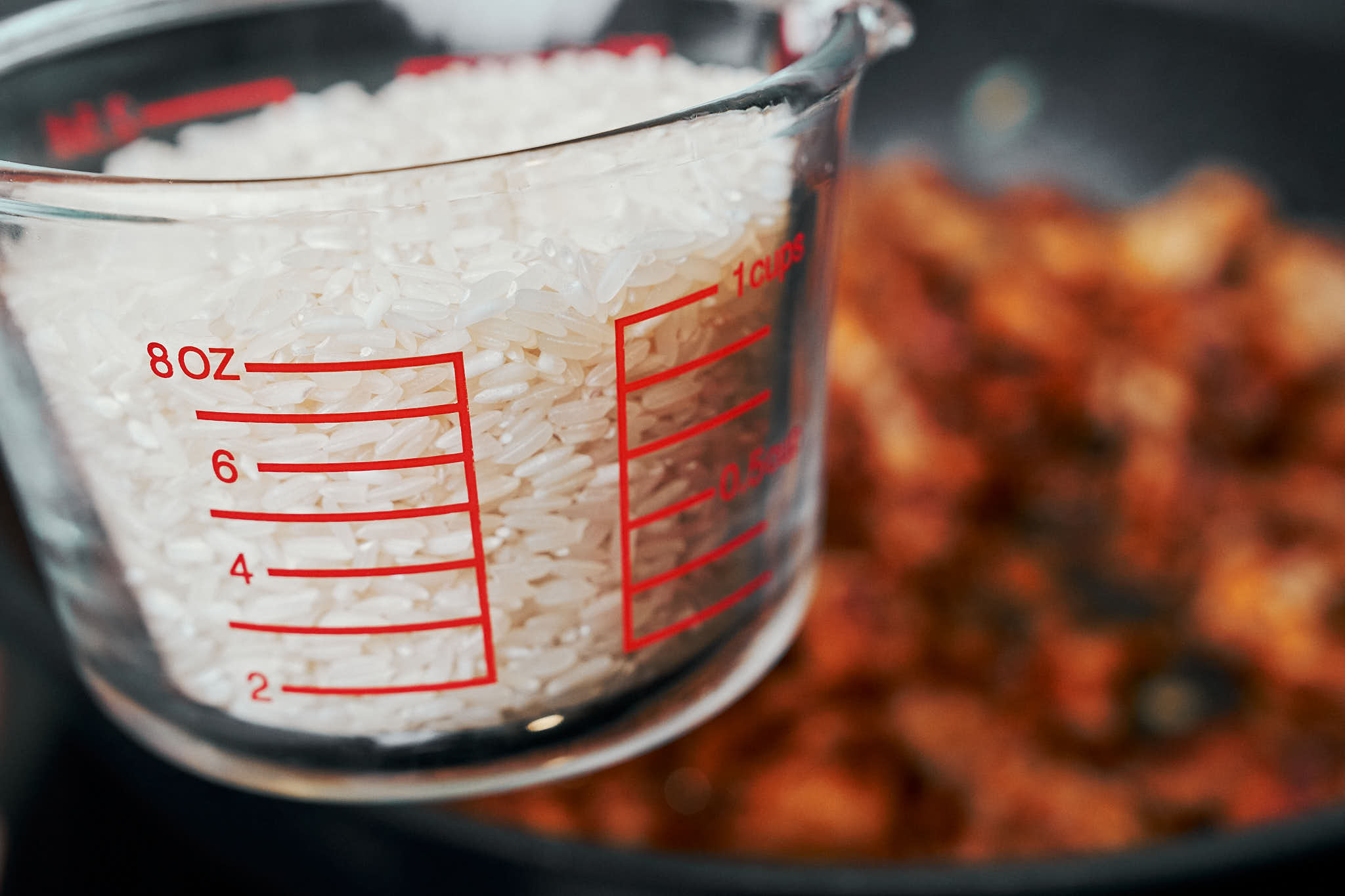 measured long grain white rice in a glass measuring cup