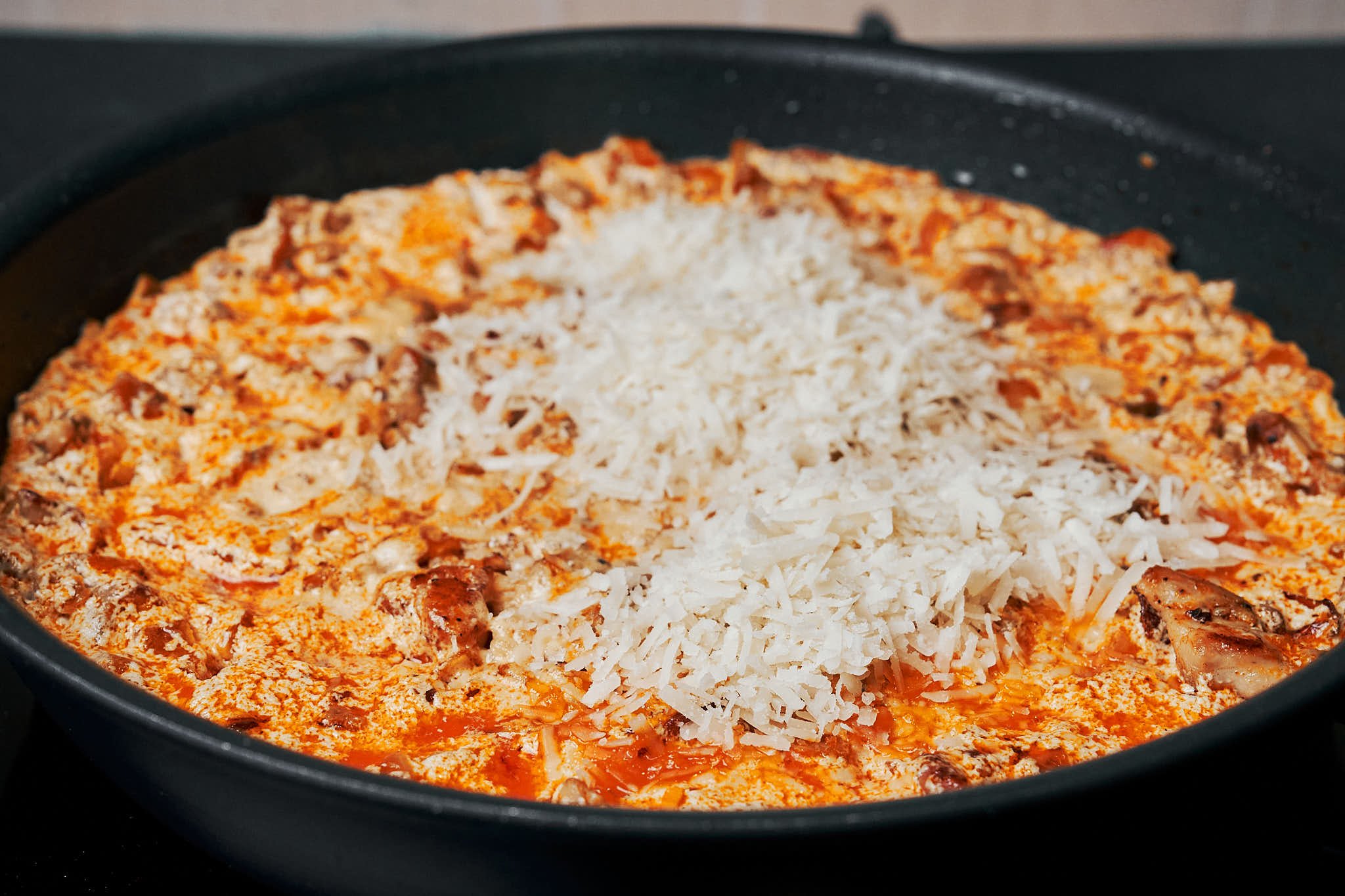 creamy chicken and rice finished with grated parmesan in a skillet