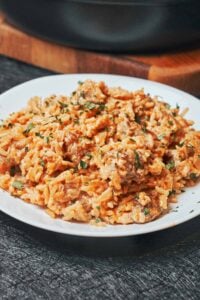 one pot creamy chicken and rice served in a plate with parmesan and herbs
