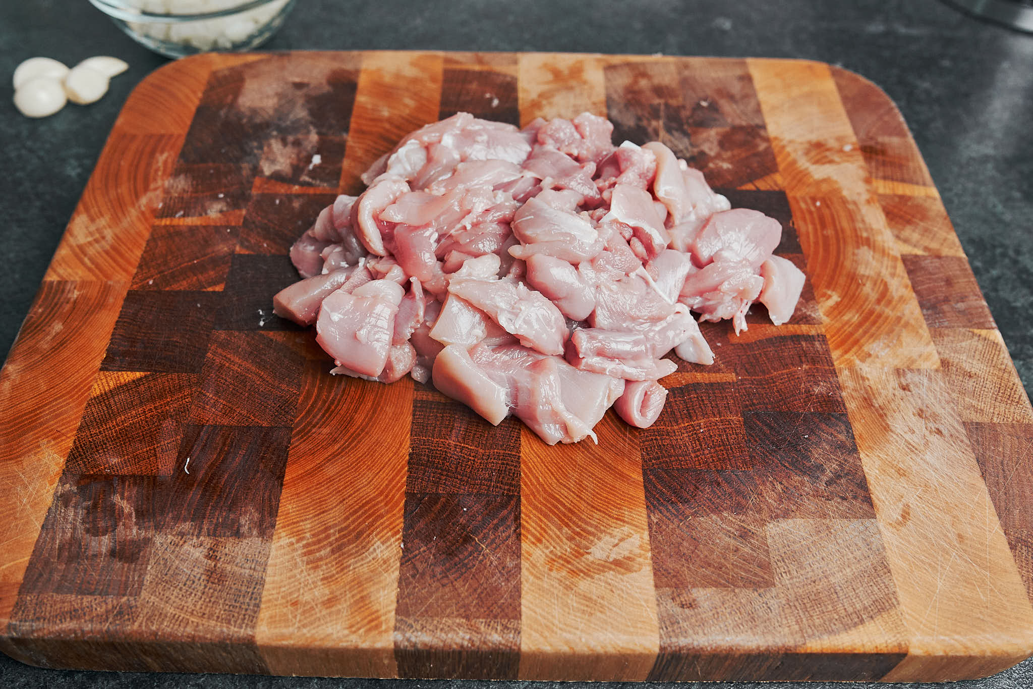diced chicken thighs on a wooden cutting board