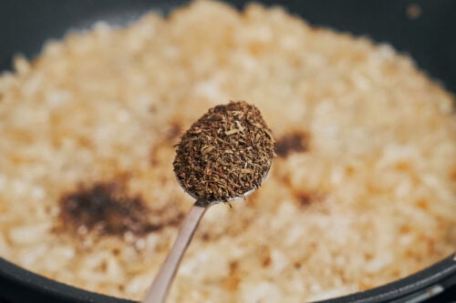 thyme added to caramelized onions in skillet