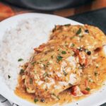 creamy chicken thighs in bacon mustard sauce on plate with rice