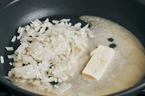 adding diced onion to butter in skillet