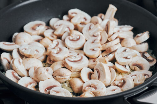 fresh sliced mushrooms just added to the skillet