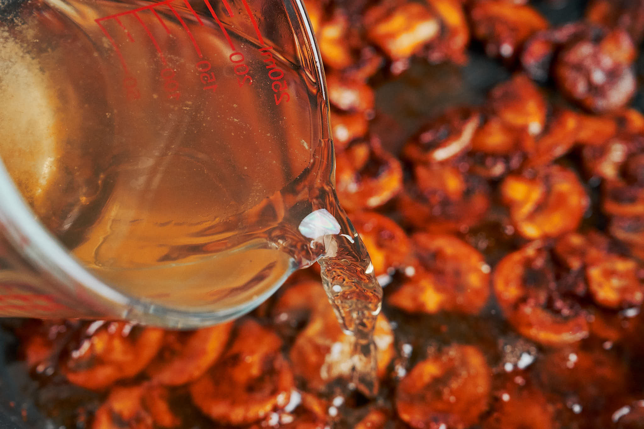 pouring beef broth into skillet to build the stroganoff sauce