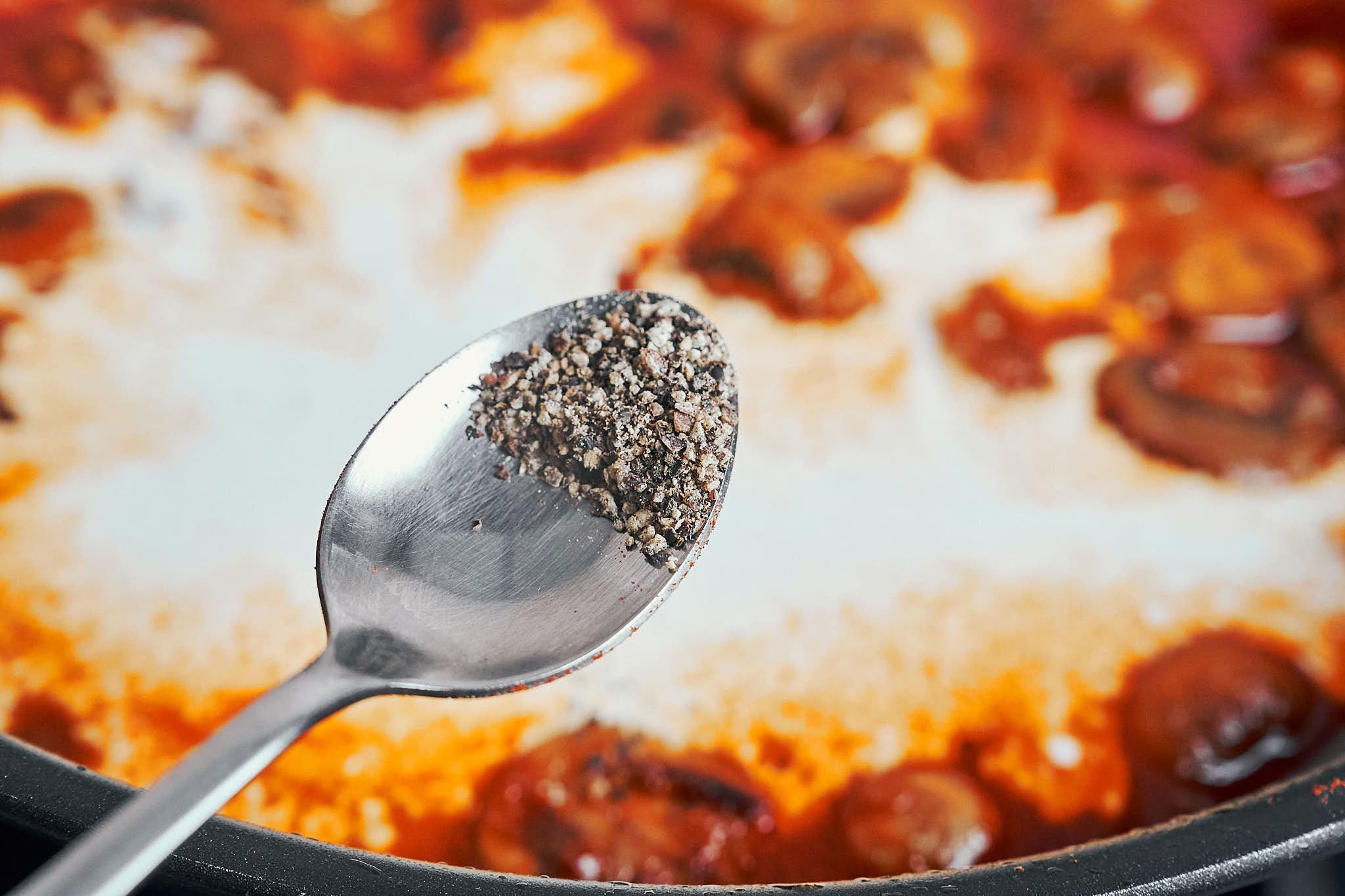 adding black pepper to creamy stroganoff sauce