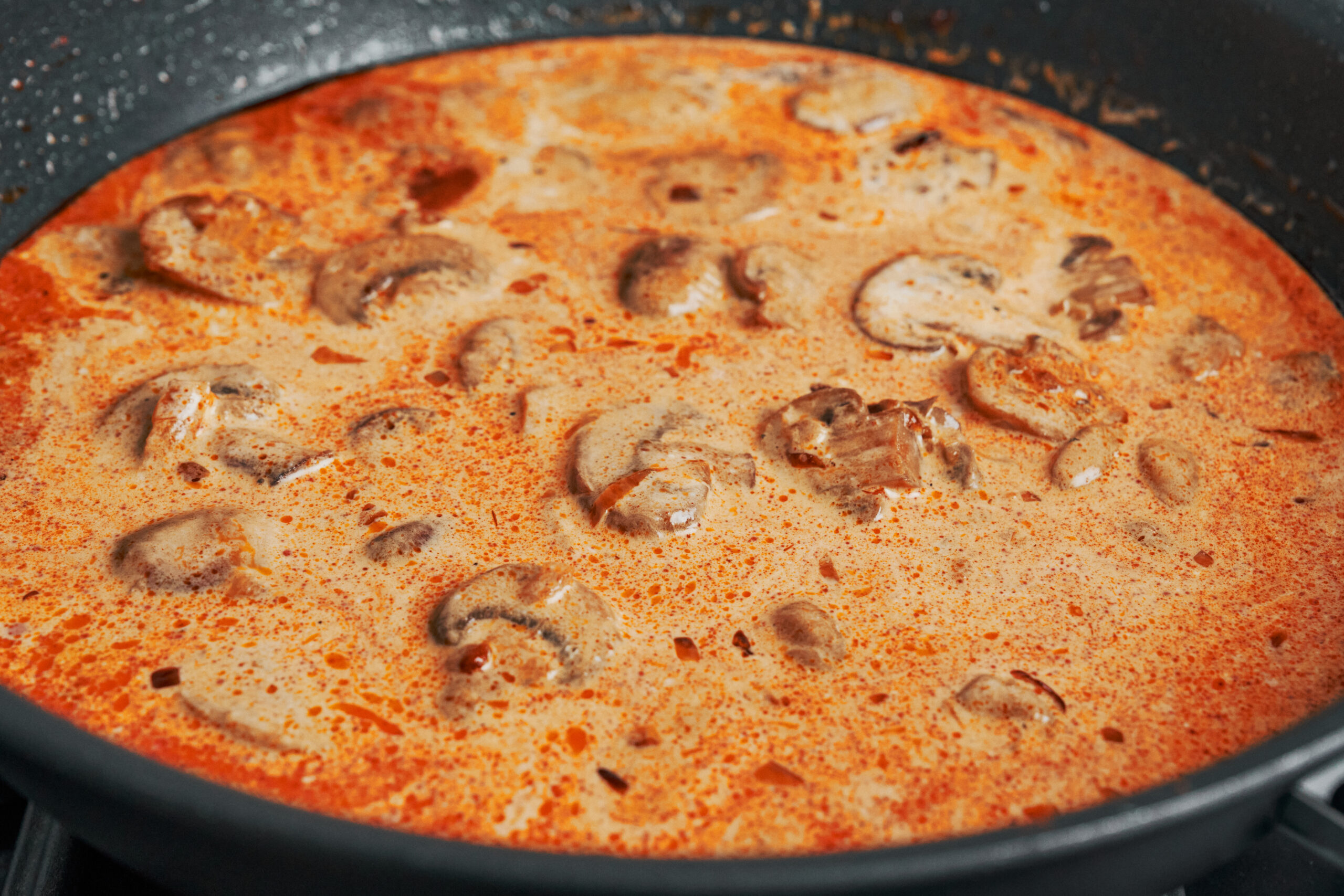 rich creamy sauce gently simmering in skillet