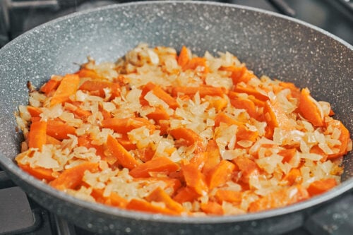 onions and carrots cooking together for pork stew base