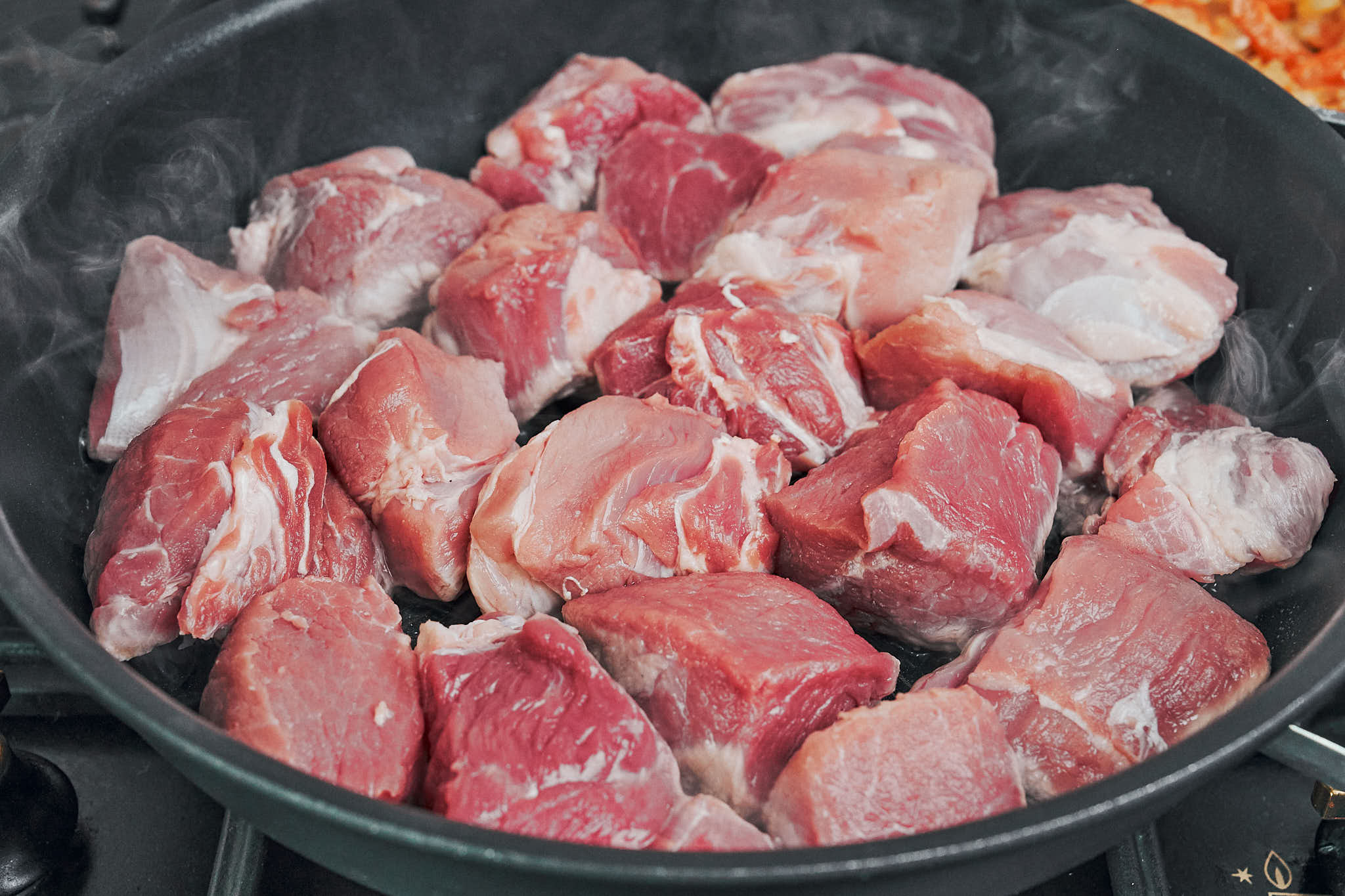 browning pork cubes in skillet over high heat
