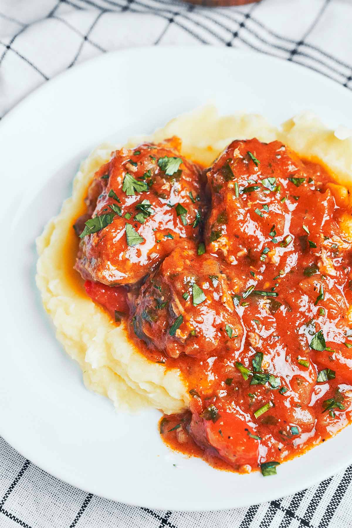 pork stew served over creamy mashed potatoes with fresh parsley