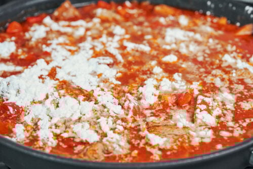 flour scattered over pork stew before stirring