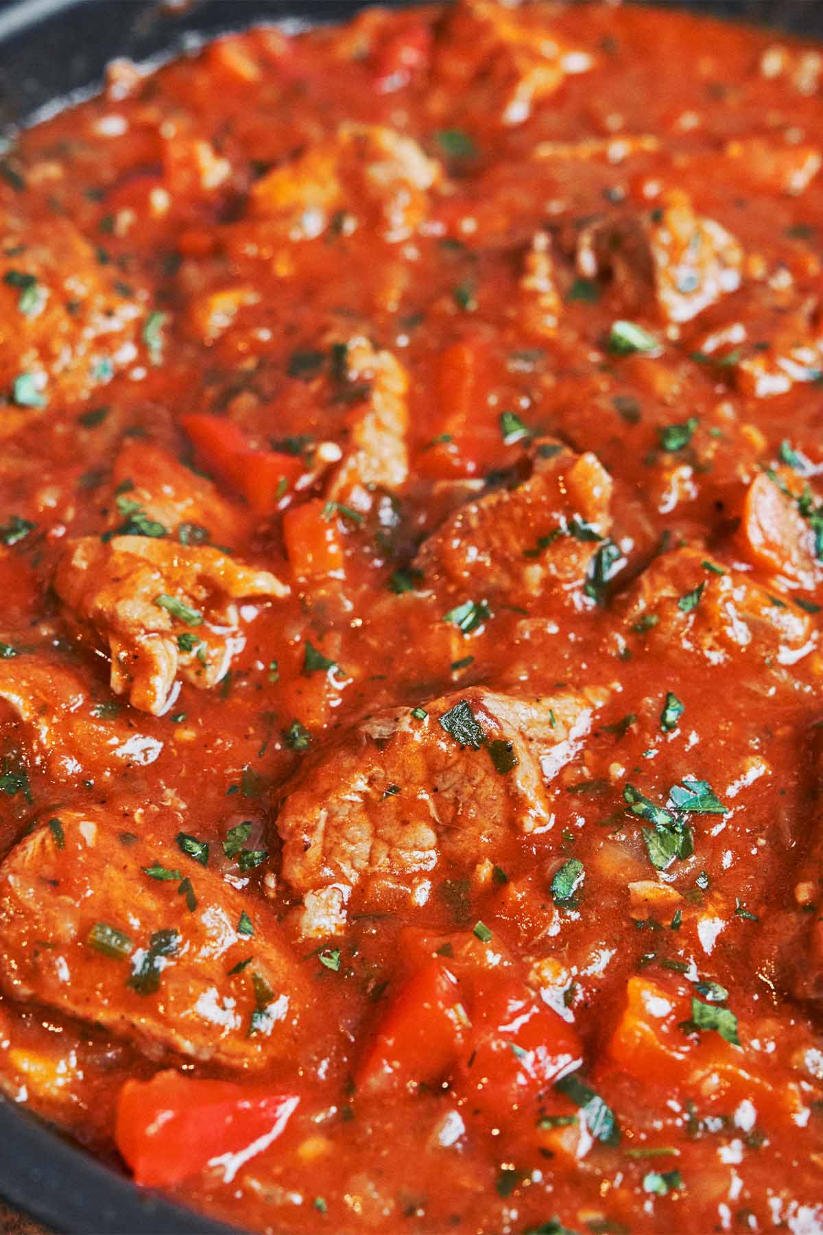 hearty pork stew with tender pork and bell peppers in rich tomato sauce