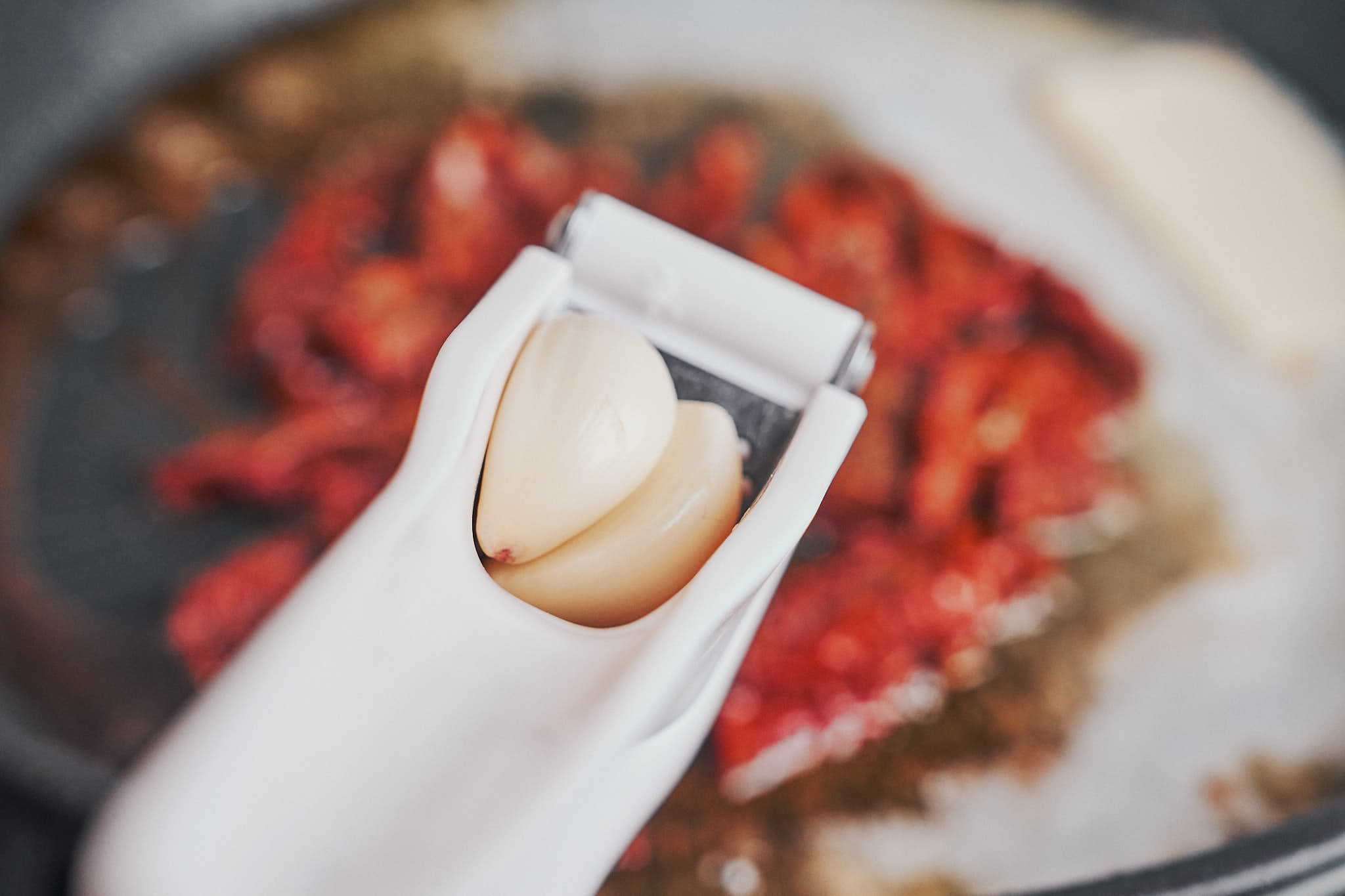 fresh garlic being added to sun dried tomatoes in the skillet