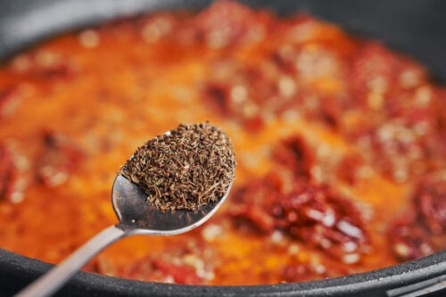 adding dried thyme to the skillet sauce