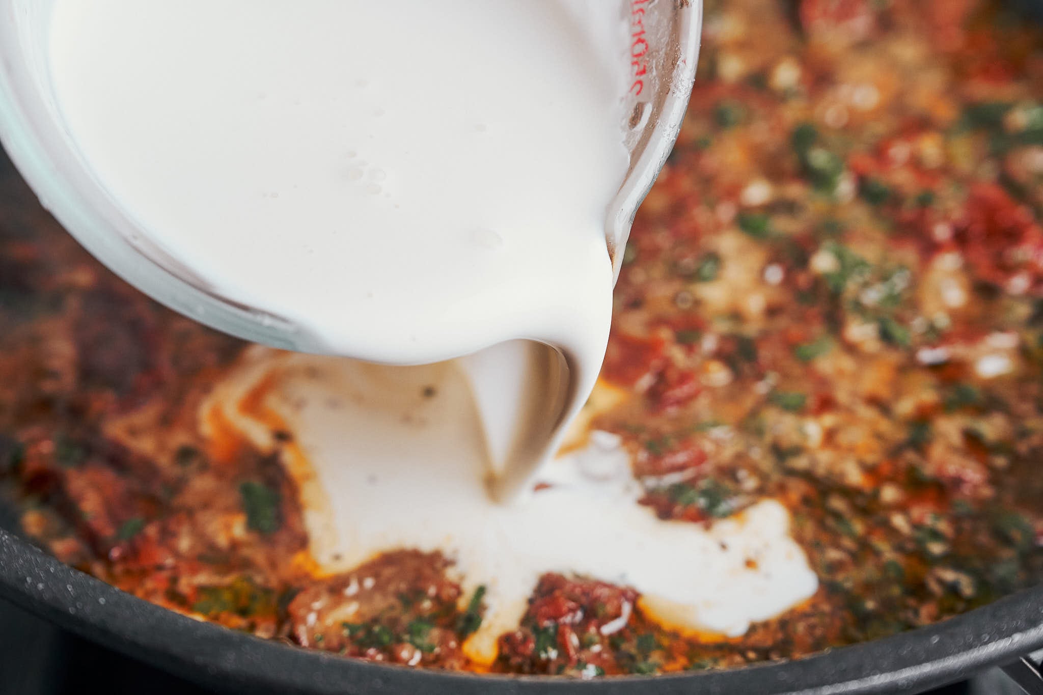 heavy cream being added to create a rich creamy sauce
