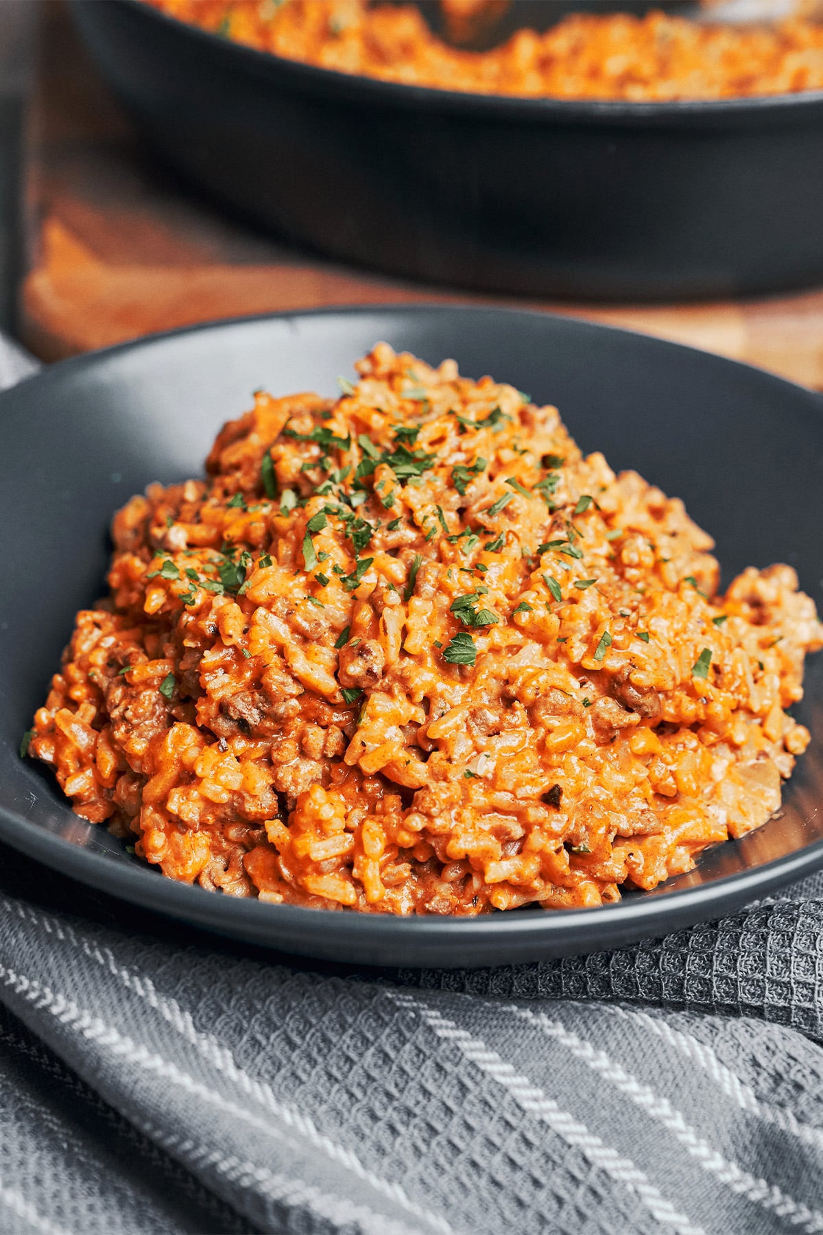 a warm serving of creamy tomato ground beef and rice skillet with fresh parsley on top