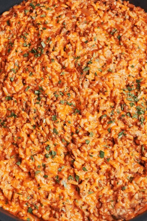 creamy tomato ground beef and rice skillet finished with fresh parsley and ready to serve