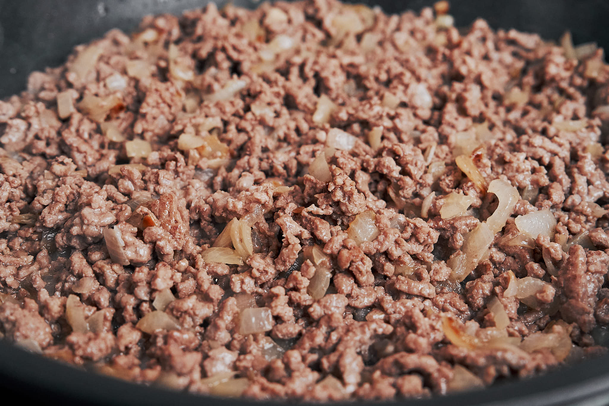 ground beef cooking down in the skillet until browned and full of savory flavor
