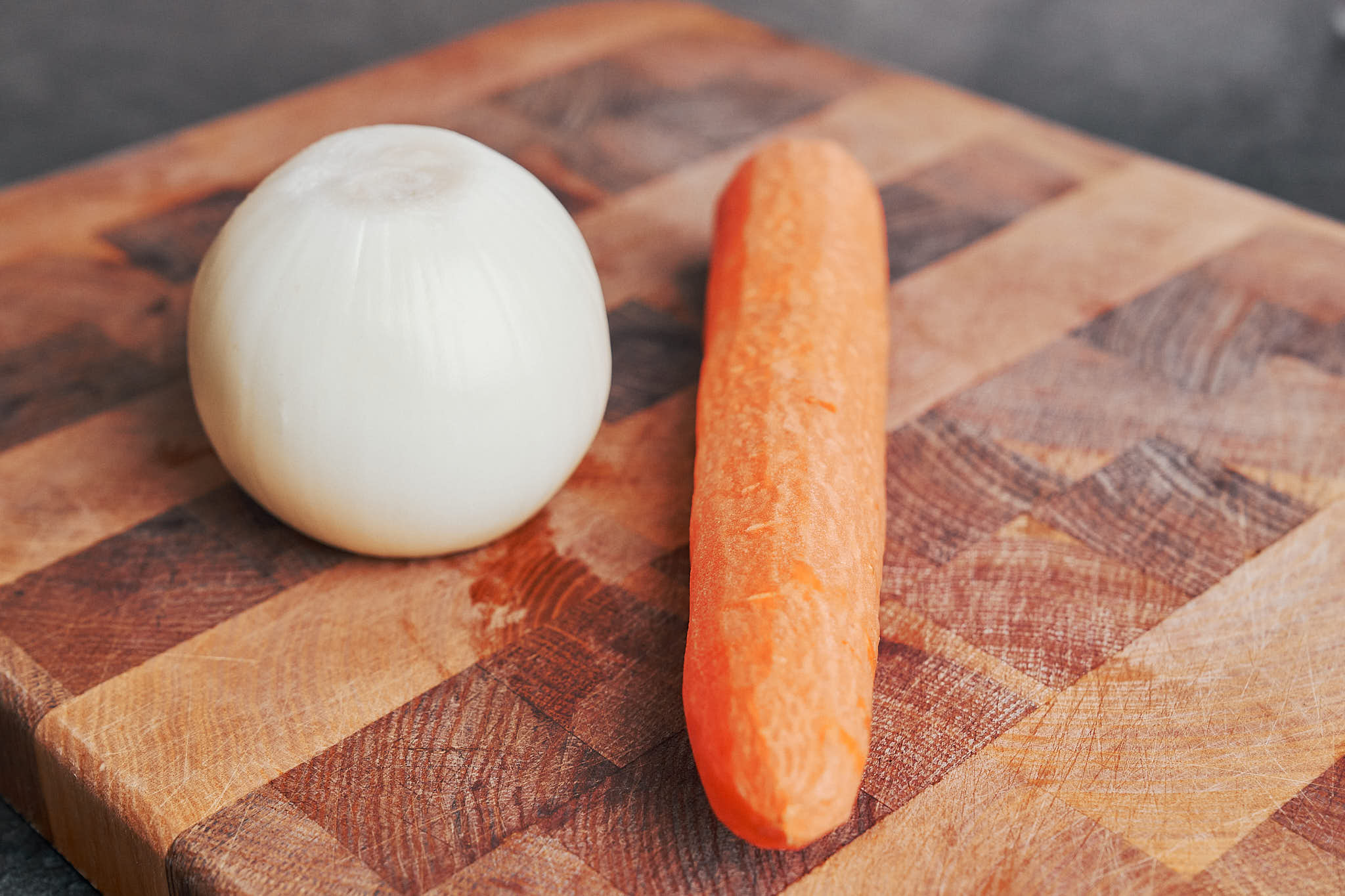 a whole onion and carrot on the cutting board
