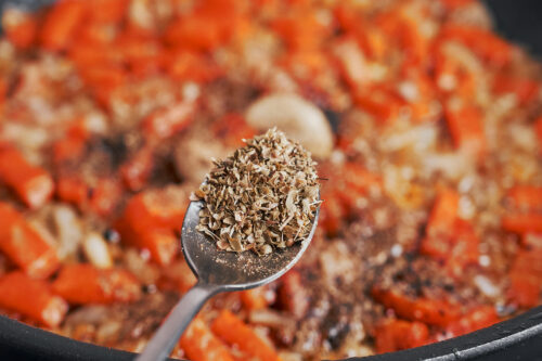 oregano being sprinkled over the vegetables