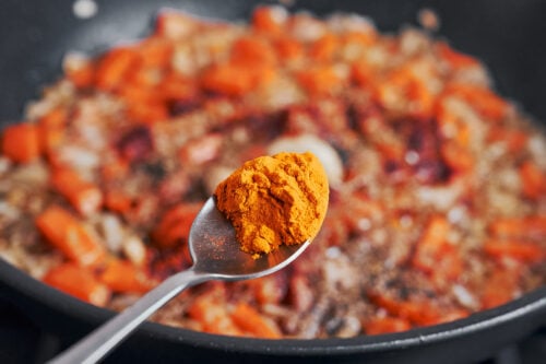 turmeric being added to the skillet for warm color