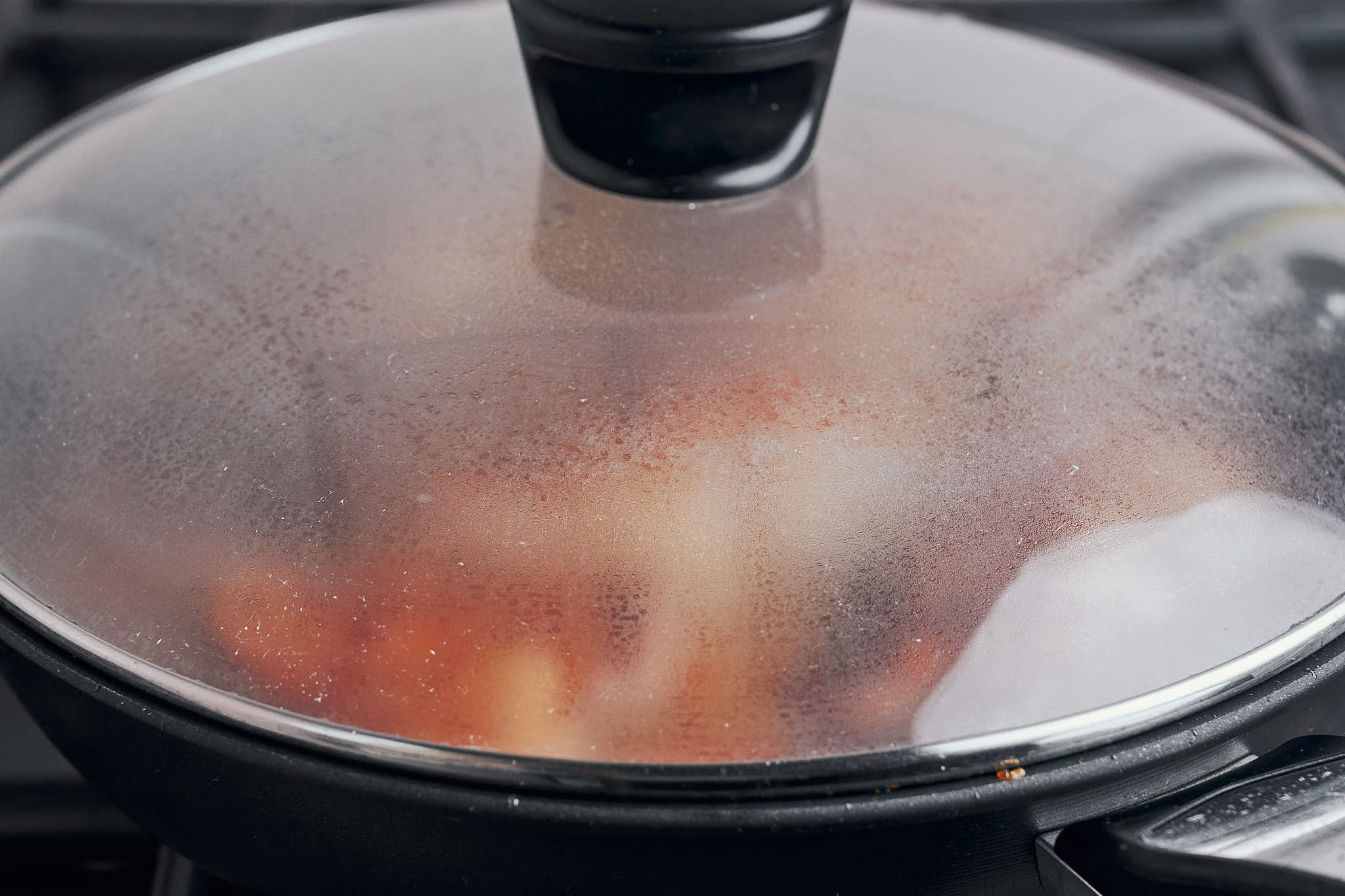 covering the skillet so the chicken can simmer gently