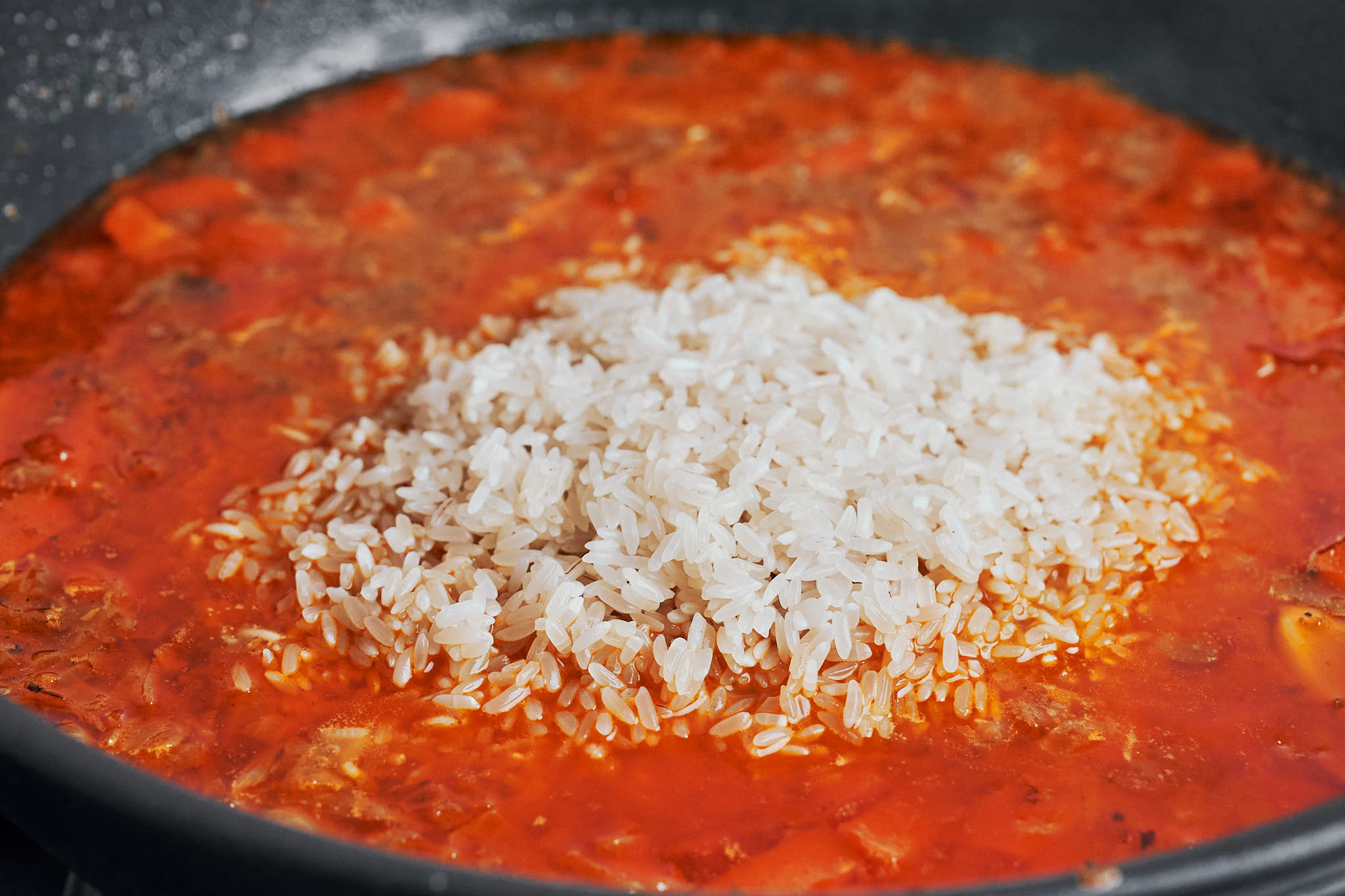 drained rice added over the simmering skillet base