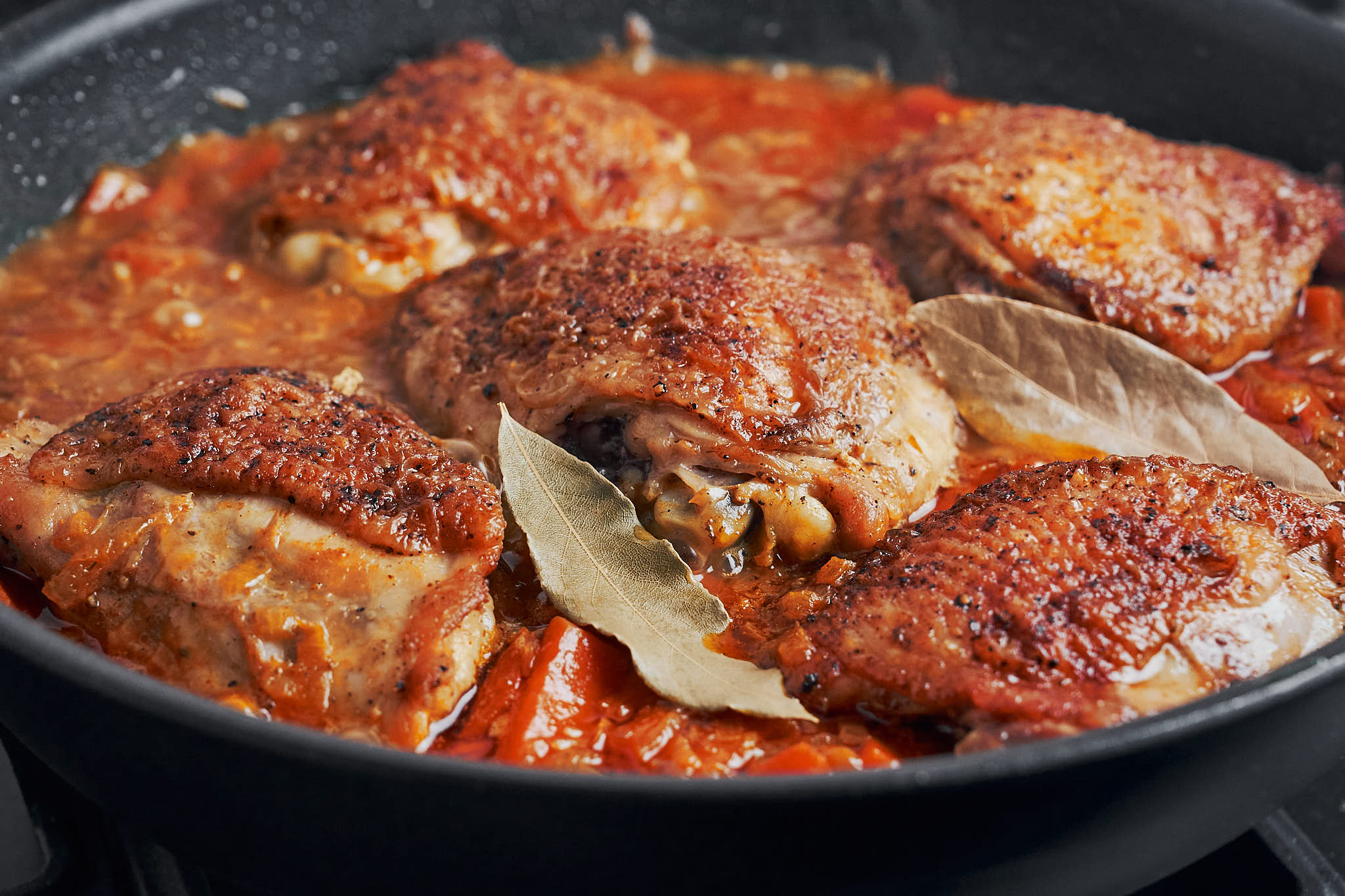 golden chicken and bay leaves set on top before covering