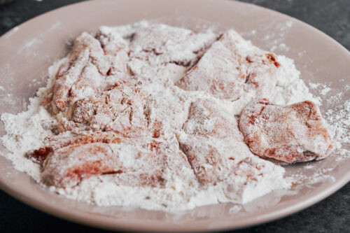 chicken pieces coated in flour before searing in skillet