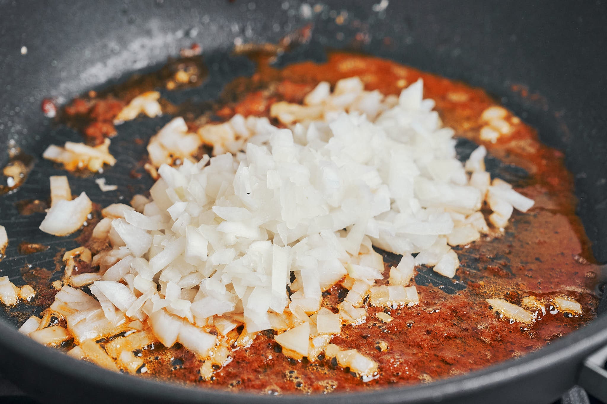 chopped onion sautéing in a skillet after searing chicken