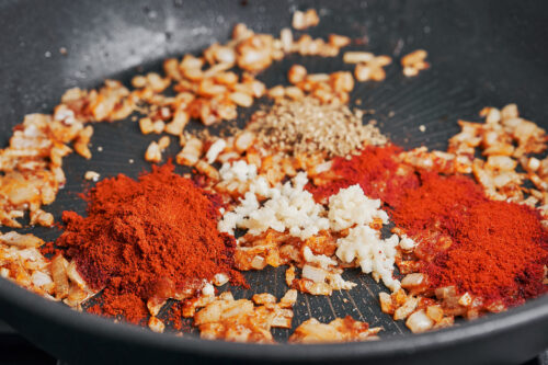 paprika and spices cooking with onions in skillet