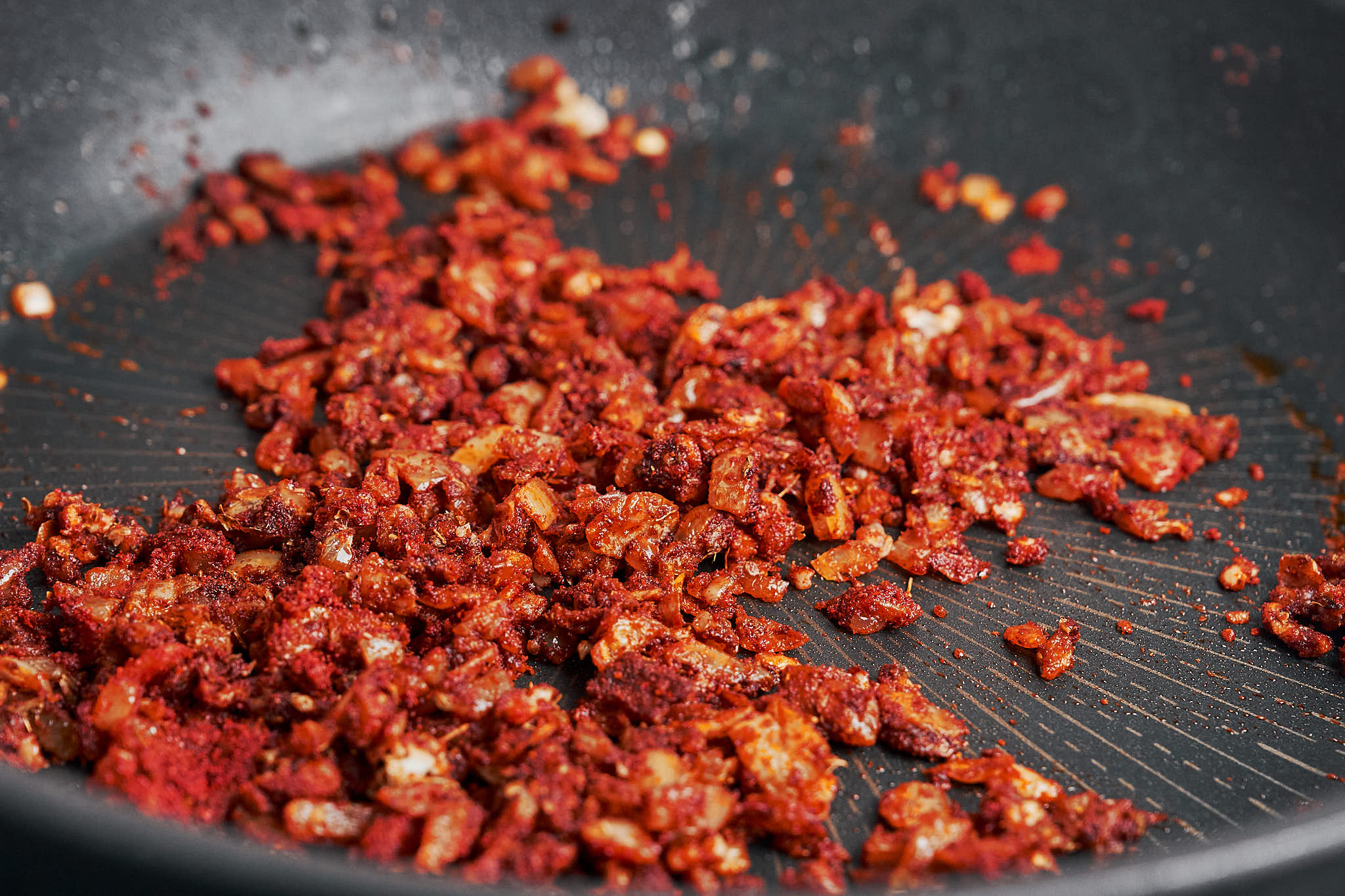 spices cooking with onions to develop flavor in skillet