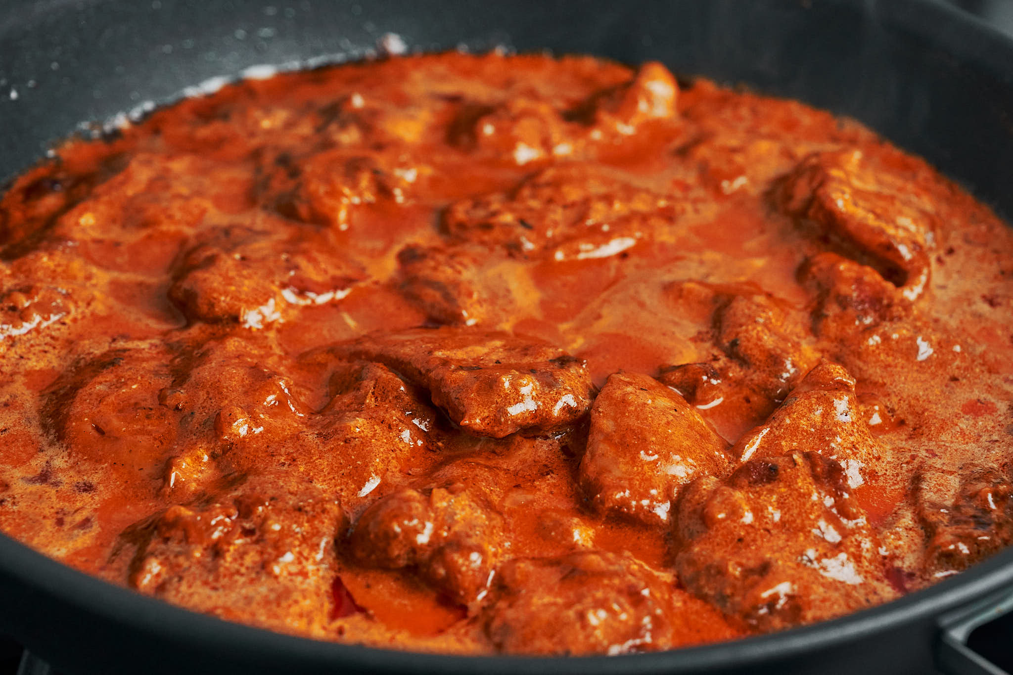tender chicken simmering in a rich creamy paprika sauce in the skillet