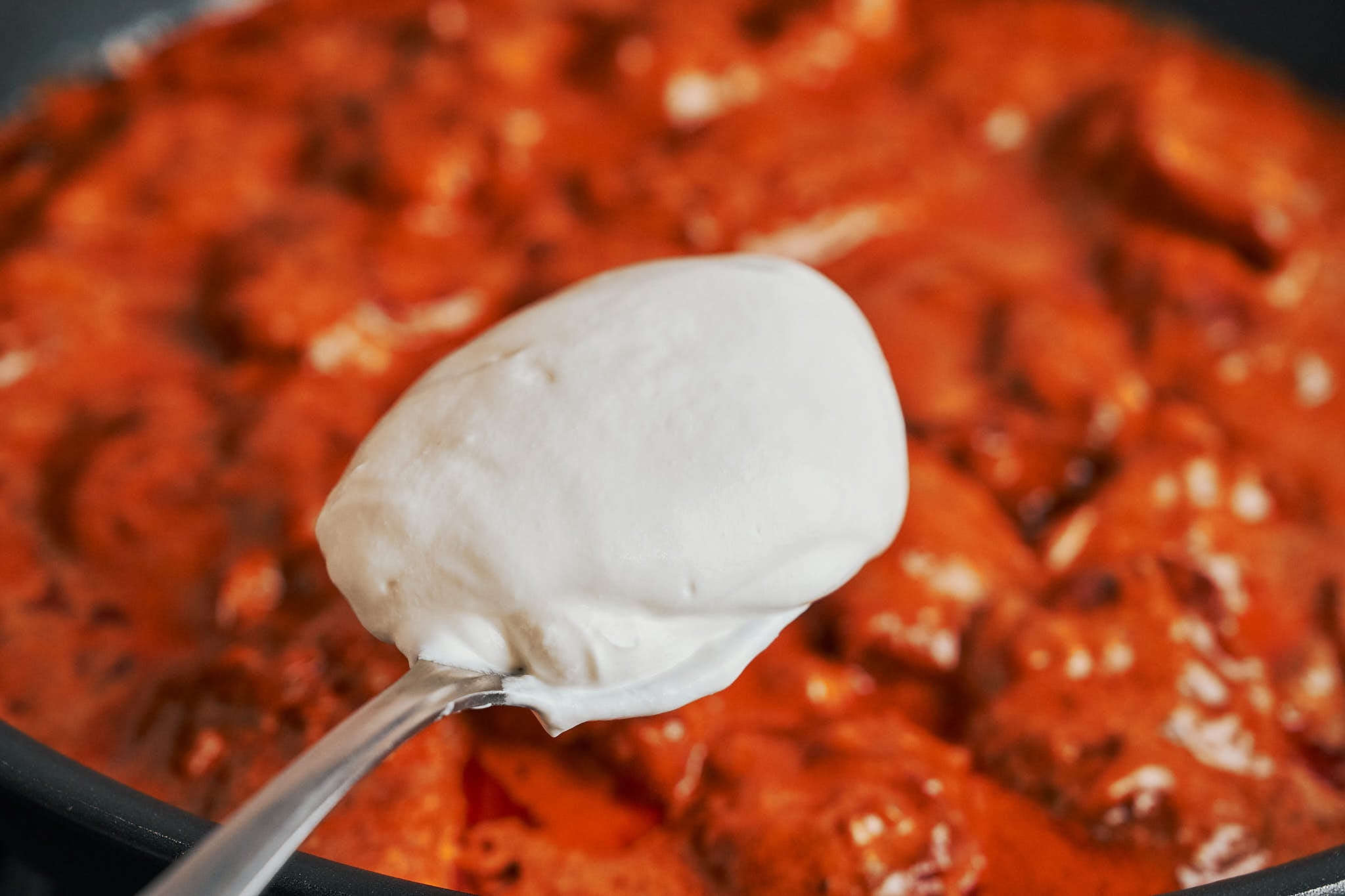 adding a spoonful of sour cream to make the paprika sauce extra creamy