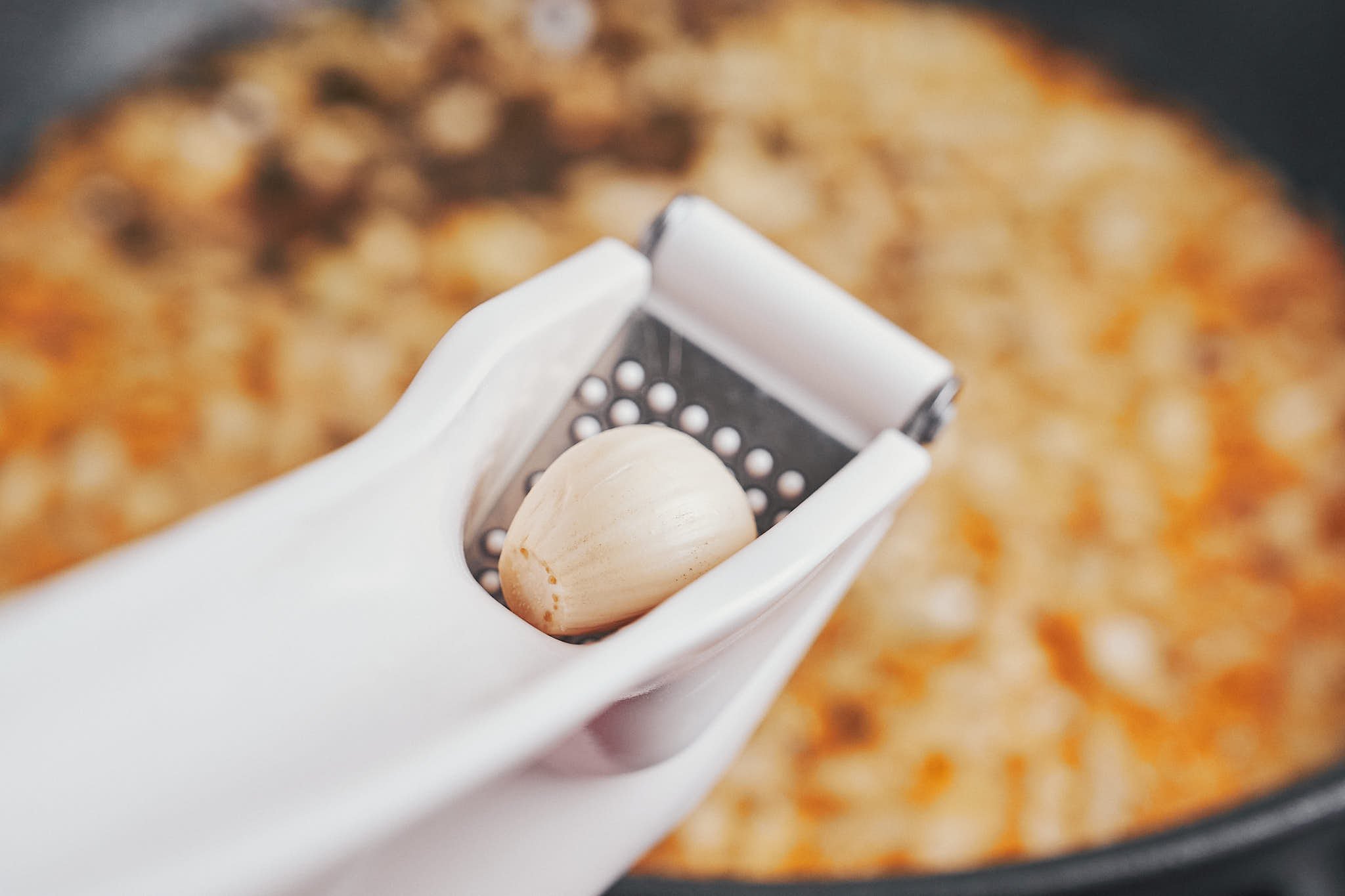 adding fresh garlic to the skillet for extra flavor in the creamy Dijon sauce