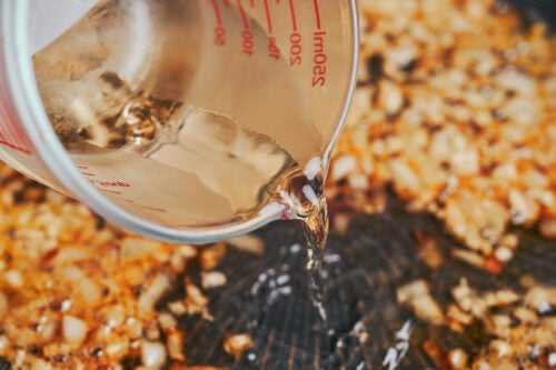 adding white wine to build flavor for the creamy Dijon sauce