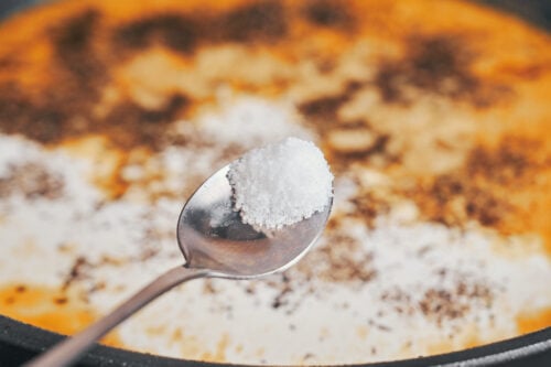 seasoning the creamy sauce with salt before the chicken goes back into the skillet